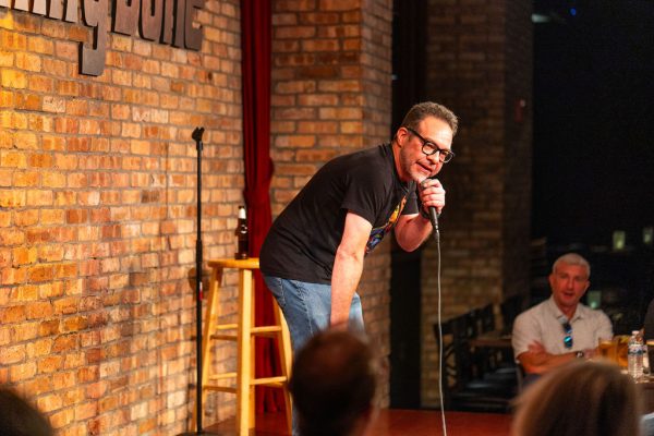 A comedian leaning into the crowd during the 2025 Comedy Jam