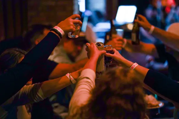 Guests raising their glasses and bottles in a toast
