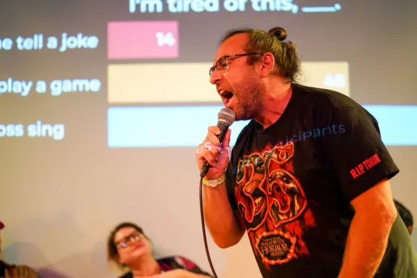 A comedian leaning forward and shouting into the microphone